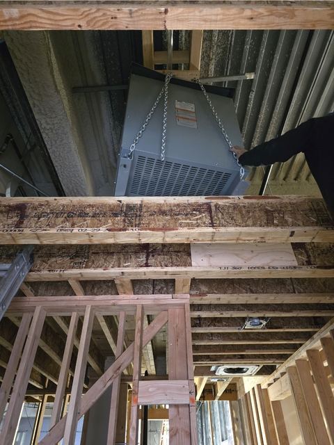 Electrical transformer hung from the framing in a building under construction